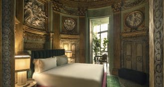 Blick in eines der Schlafzimmer des Palazzo Vilòn in Rom, in dem barocke Elemente für eine stimmige Atmosphäre sorgen.